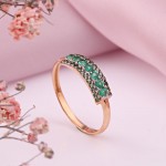 Zlatý prsten s diamanty a smaragdem.