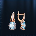 Earrings made of soot gold with topaz. Bicolor